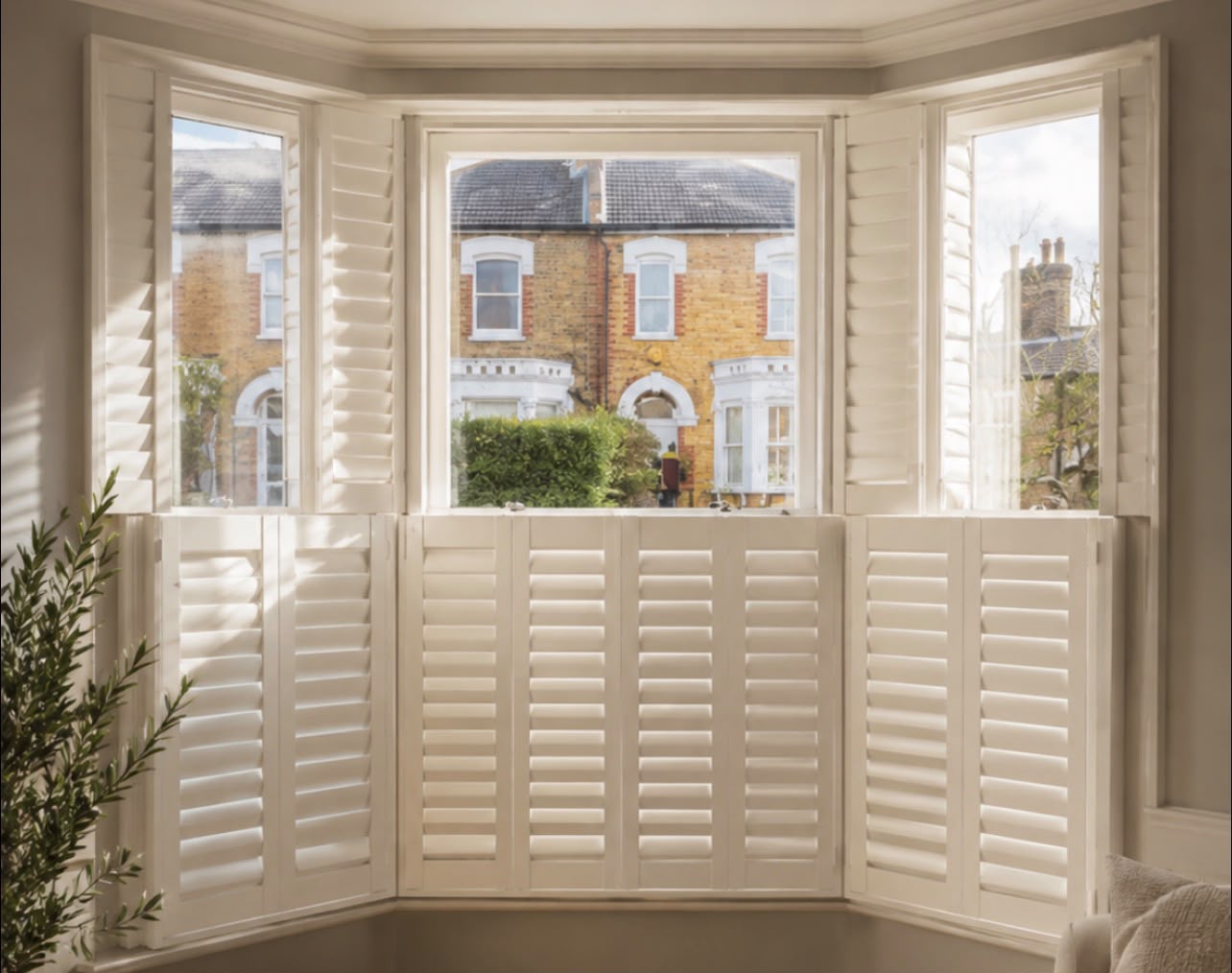 Bay window fitted with white plantation shutters